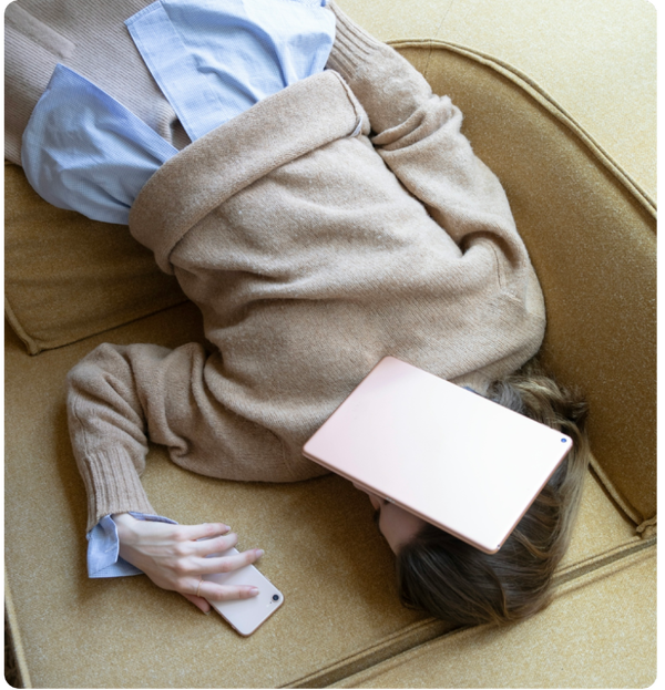 Sliten dame på sofa med gadgets