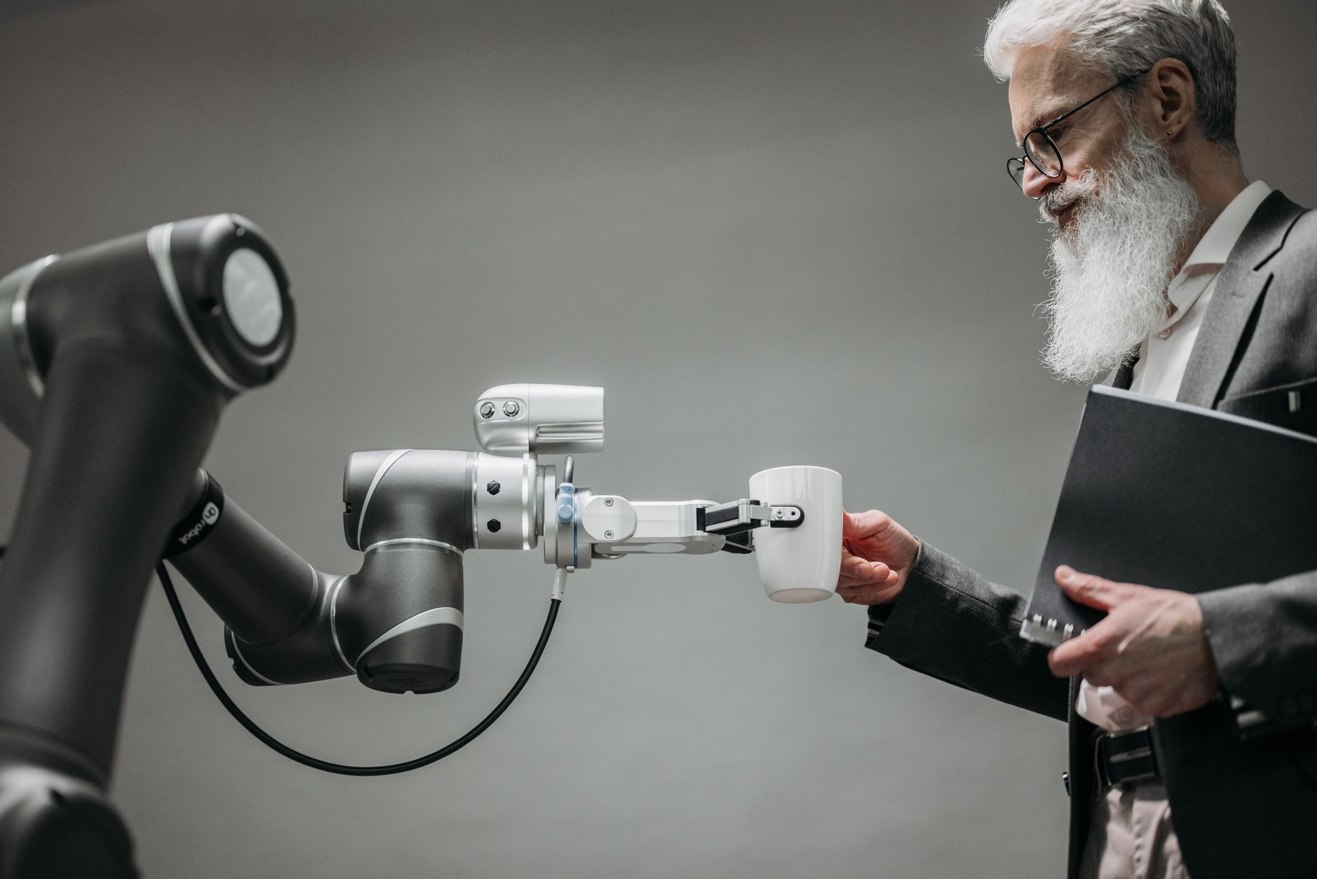 Robotarm rekker en kopp kaffe til en mann i dress